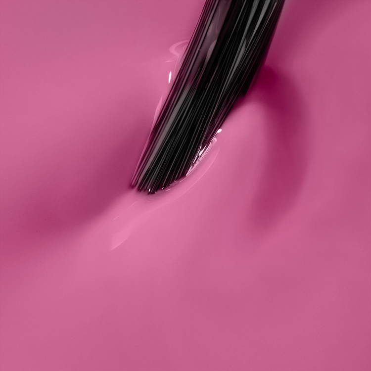 Brush applying vibrant pink UV gel polish, perfect for autumn manicures and home nail kits.