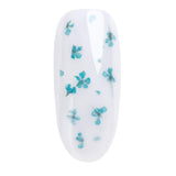 Turquoise dried flowers on a nail design for easy UV gel nail art, enhancing home manicure kits with floral accents.