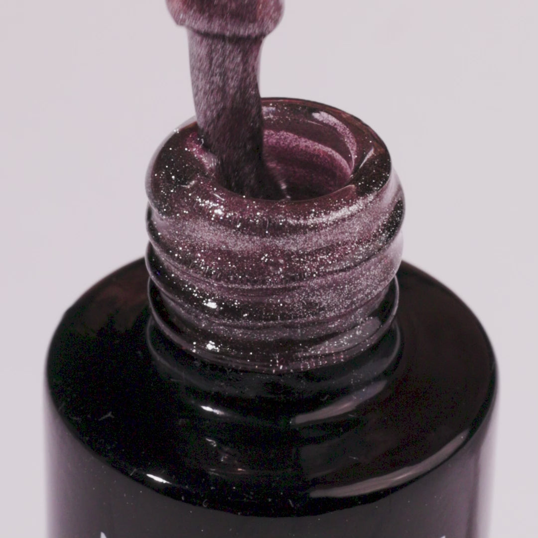 Close-up of Arctic Blush UV gel nail polish bottle showcasing shimmering beige color and brush dipped in gel.