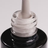 Close-up of Days Without Pressure cool beige UV gel nail polish in a bottle with applicator.