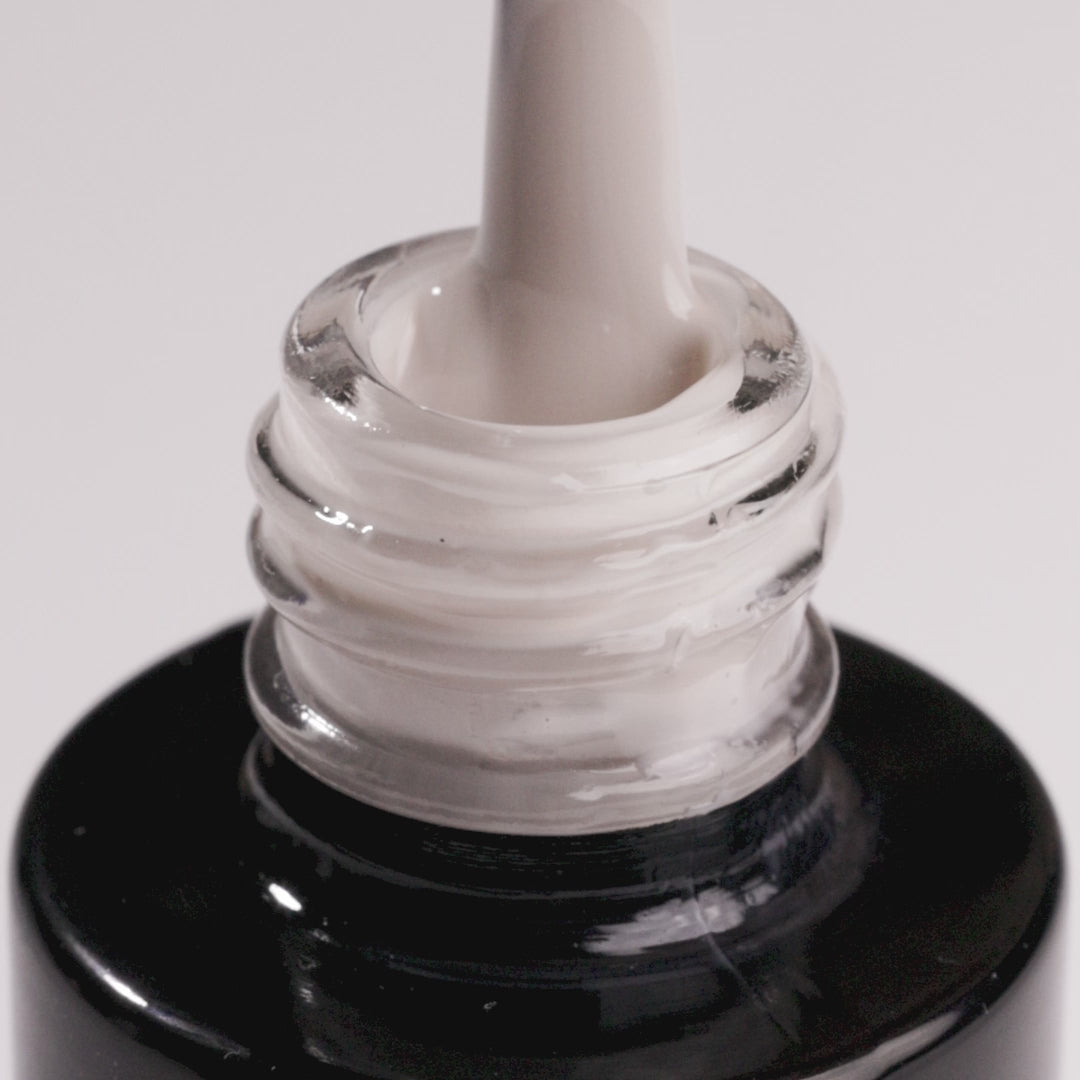 Close-up of Days Without Pressure cool beige UV gel nail polish in a bottle with applicator.