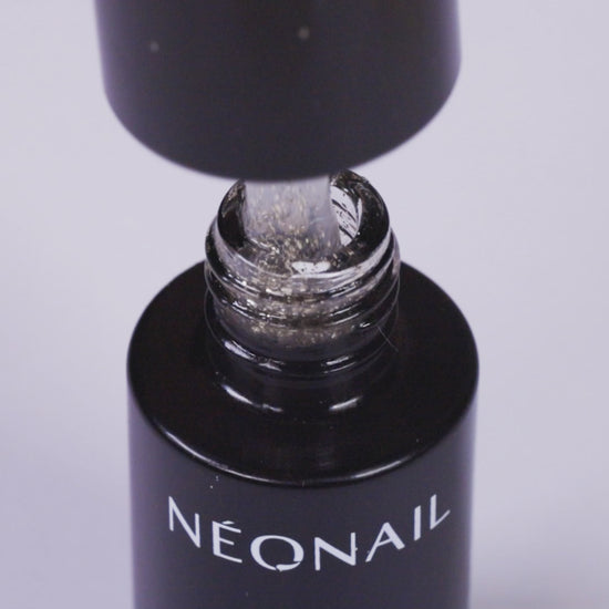 NÉONAIL Gold UV/LED Top Glow Flakes Gel Polish bottle being opened, showcasing glittery gel polish inside.