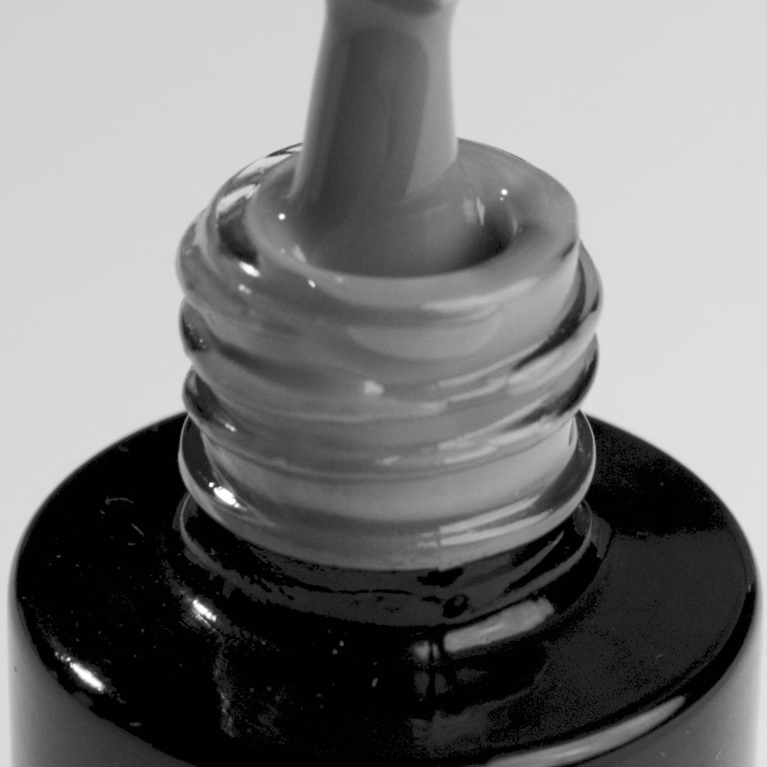 Close-up of Independent Spirits graphite grey UV gel nail polish bottle, showcasing the applicator.