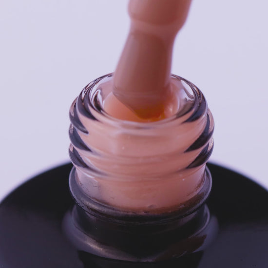 Close-up of Neutral Nude expert UV gel polish being applied from a bottle for flawless nail styling.