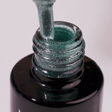 Snowstorm Glow UV gel polish bottle with green glitter pouring out, perfect for dazzling manicures at home.