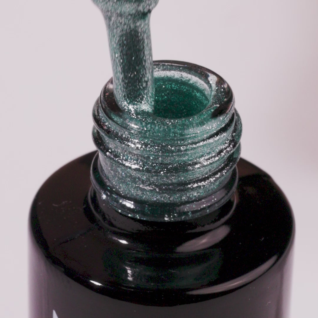 Snowstorm Glow UV gel polish bottle with green glitter pouring out, perfect for dazzling manicures at home.